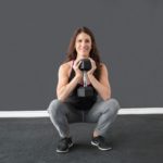 Woman squats with weight