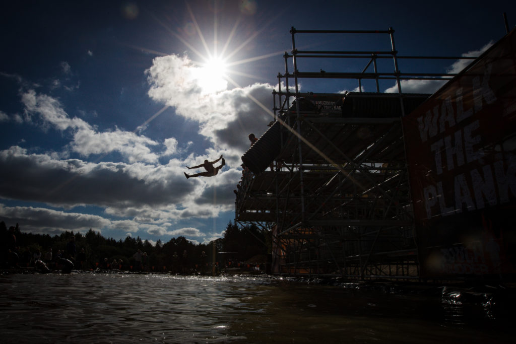 A man jumps from a platform into water