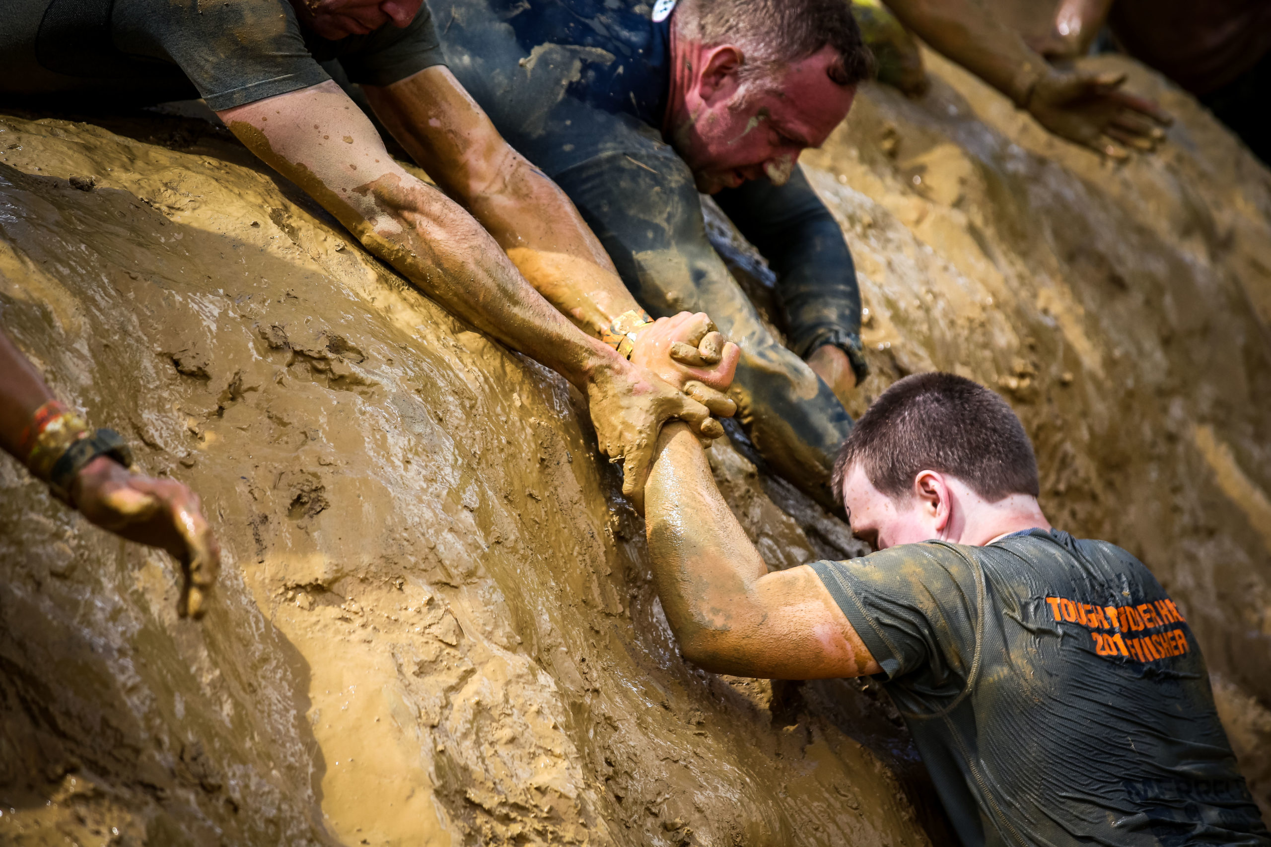 Participants helping their teammate to climb