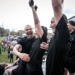 team of people cheer top of obstacle at Finsbury event